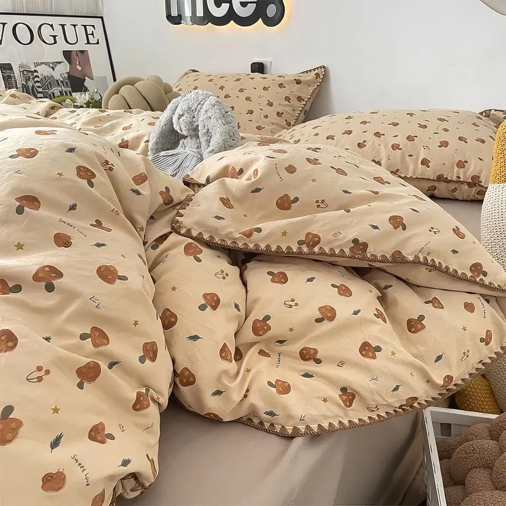 Beige bedding set with mushroom pattern on a bed, featuring pillows and a plush toy.