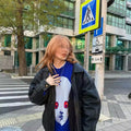 TikTok viral fashion piece with graphic face design in cozy winter knitwear.