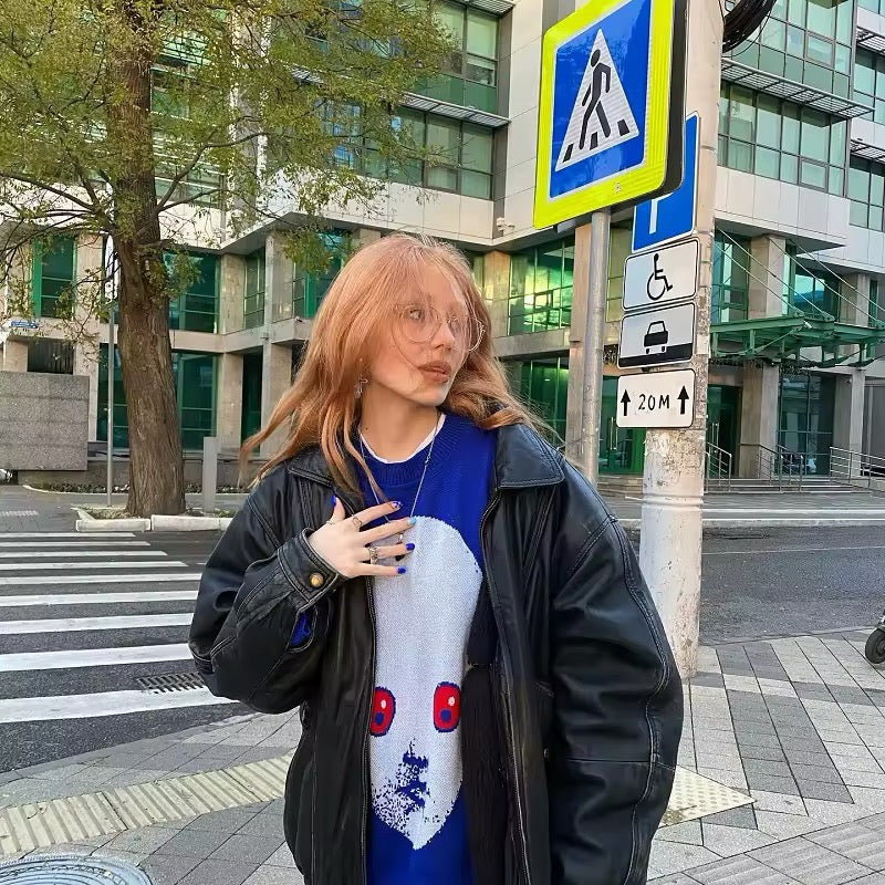 TikTok viral fashion piece with graphic face design in cozy winter knitwear.