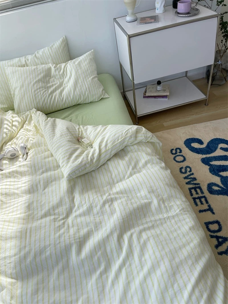Bed with white bedding and pillows next to a nightstand with decorative items.