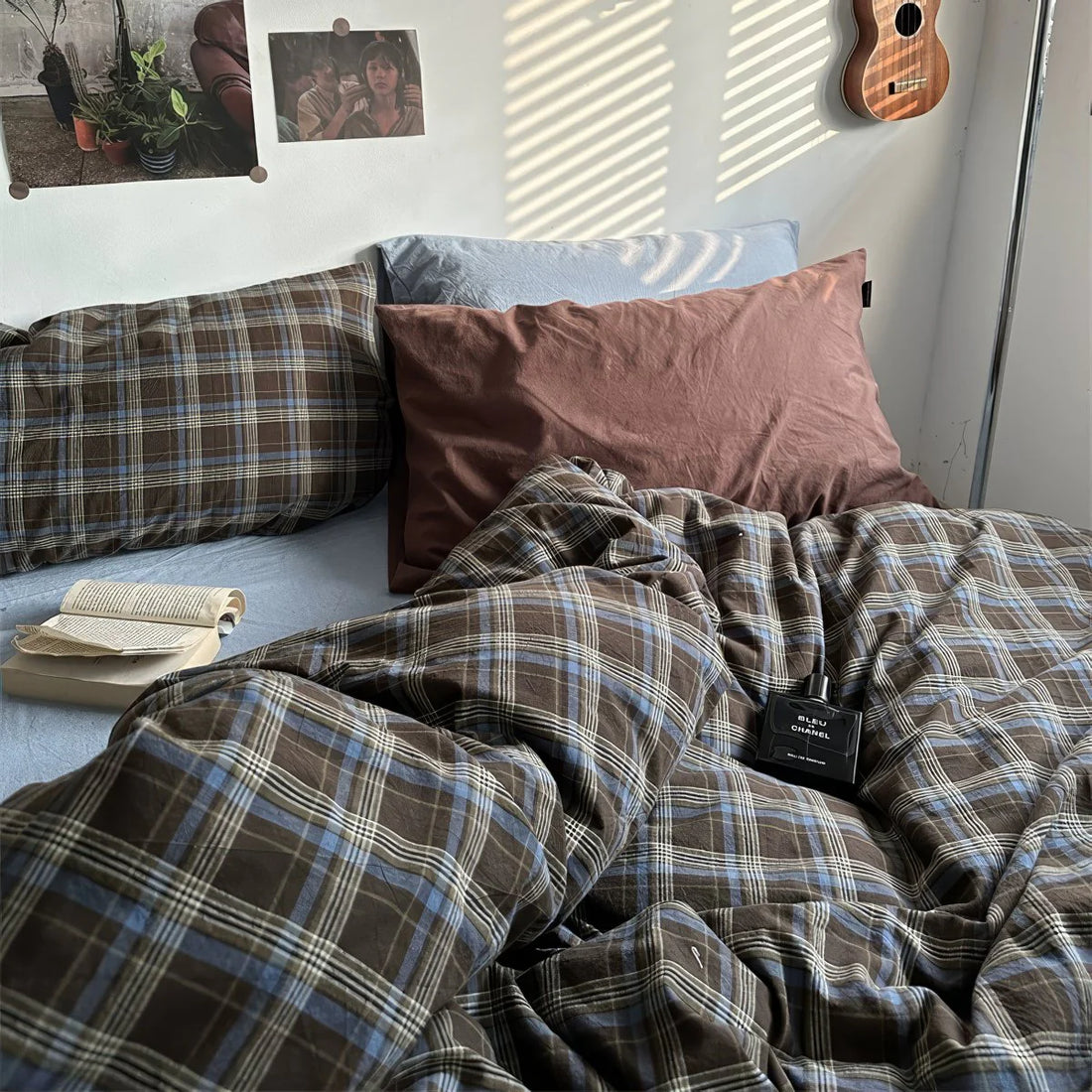 Bed with plaid bedding and pillows in a bedroom setting.