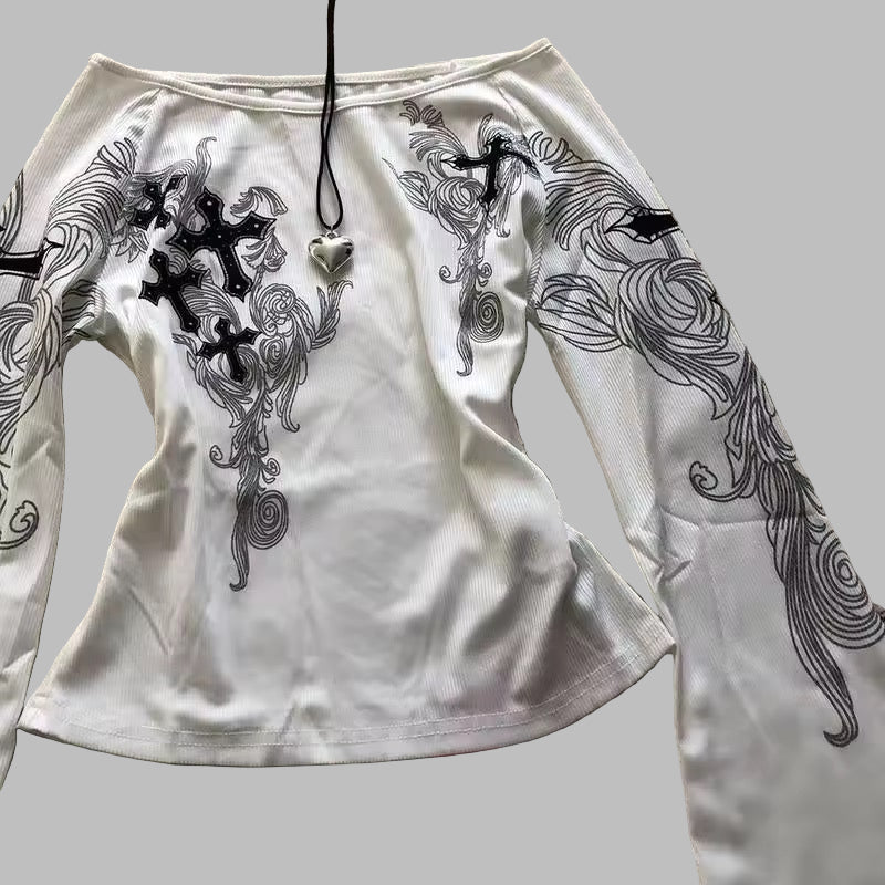 White long-sleeve shirt with black intricate designs on a textured surface