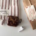 Wireless-ready brown AirPods case on desk