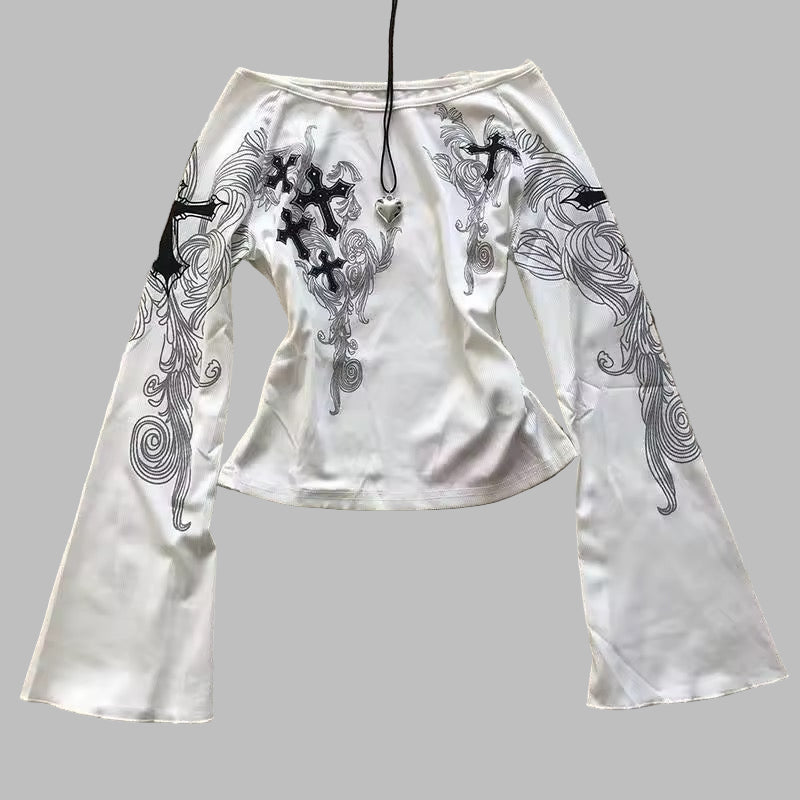 White outfit with black embroidery on a textured surface