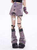 Model wearing purple mini skirt with crossover ribbon detail and cutout threads