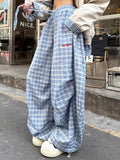 Light blue plaid wide leg pants with elastic waistband and drawstring, styled for Y2K streetwear