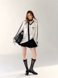 Full-body photo featuring the white sporty top paired with a black mini skirt.