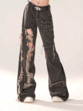 Side profile highlighting the baggy fit and hollow-out rips on the black denim trousers.