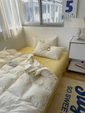 Bedroom with a bed, pillows, and a window with blinds.