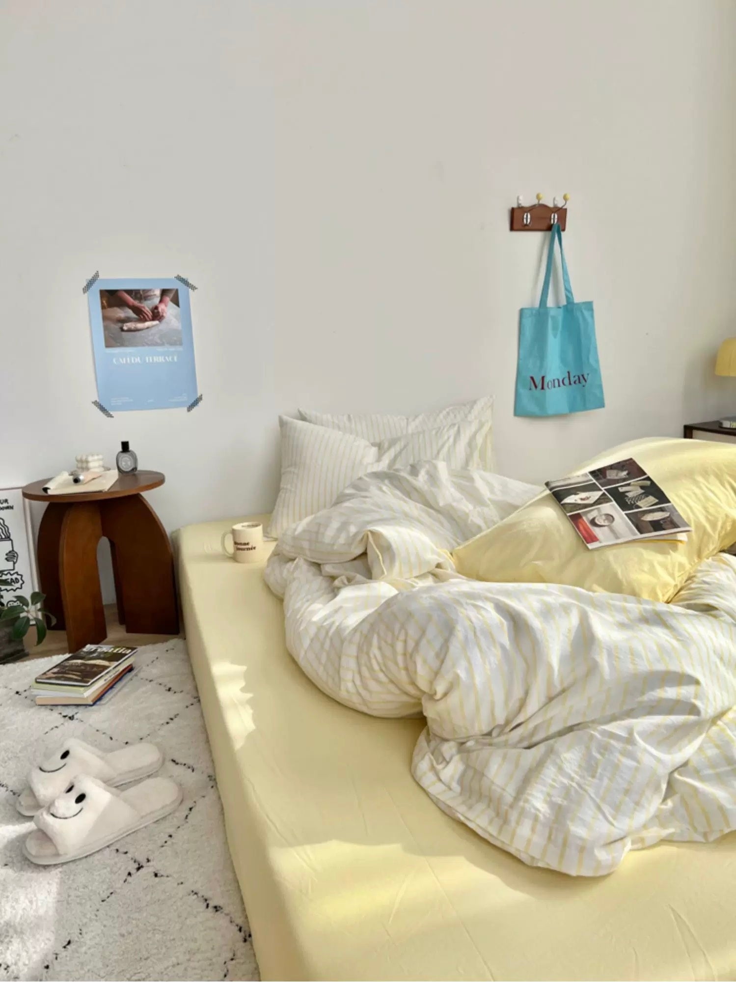 Bedroom with a bed, pillows, and a small table with a lamp.